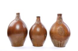 THREE MASSIVE GERMAN STONEWARE BARTMANN OR BELLARMINE JUGS 17TH/18TH CENTURY all with moulded