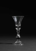 A HEAVY BALUSTER WINE GLASS C.1720 the flaring trumpet bowl above basal and spherical knops,