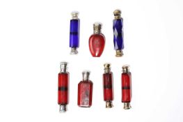 A COLLECTION OF FIVE VICTORIAN DOUBLE-ENDED GLASS SCENT BOTTLES RETAILED BY GARRARDS AND OTHERS,