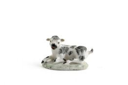 A SMALL BOW MODEL OF A RECUMBENT KID GOAT C.1750 decorated with scribbly black patches and raised on