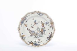 A MOUSTIERS FAIENCE DISH MID-18TH CENTURY painted with two figures in a garden, with a bird