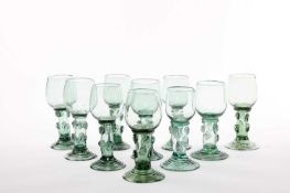 TEN CONTINENTAL GLASS ROEMERS OR RUMMERS DUTCH OR NORTH GERMAN of pale green glass, the rounded