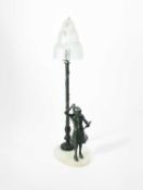 Art Deco School; A figural bronze table lamp with Sabino glass waterfall shade, circa 1920