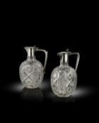 By Faberge, a pair of Russian silver-mounted cut glass claret jugs,