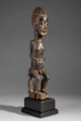 A BAULE SEATED MALE FIGURE