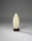 A CHINESE WHITE JADE TWO-HANDLED VASE AND COVER