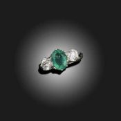AN EMERALD AND DIAMOND THREE STONE RING