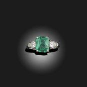 AN EMERALD AND DIAMOND THREE STONE RING