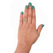 AN EMERALD AND DIAMOND THREE STONE RING