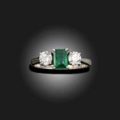 AN EMERALD AND DIAMOND THREE STONE RING, C2013
