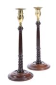 A PAIR OF MAHOGANY AND BRASS CANDLESTICKS