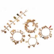 FIVE YELLOW GOLD CHARM BRACELETS