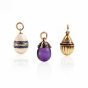 TWO RUSSIAN GOLD MINIATURE EGG PENDANTS AND AN AMETHYST MINIATURE EGG PENDANT