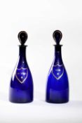 A PAIR OF BLUE GLASS DECANTERS AND STOPPERS