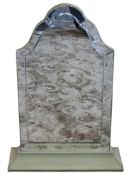 A dressing table mirror of arched form with segmented plate raised on a swept fabric covered