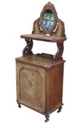 A Victorian walnut and figured walnut veneered music cabinet with inlaid detail and raised oval