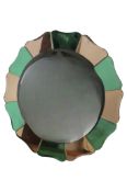 An Art Deco floral shaped tinted glass wall mirror in peach and green, 72 cm diameter