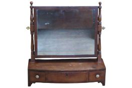 A Regency mahogany toilet mirror of rectangular form raised on a bow fronted box base fitted with