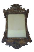 A country made wall mirror in the Chippendale style with a simulated grained finish. 66cm by 38cm.