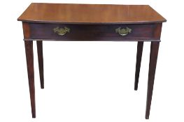A Georgian mahogany side table with bow fronted top over a shallow frieze drawer on square tapered