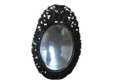 A 19th Century Chinese wall mirror with a carved and pierced frame showing dragons with mother of