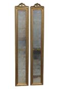 A pair of slender rectangular gilt framed pier mirrors with bevelled edge plates and tied ribbon