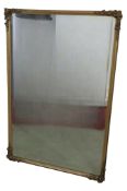 A rectangular gilt framed wall mirror with bevelled edge plate and moulded surround with trailing