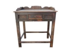 An old rustic side table possibly Chinese with raised three quarter gallery over a central frieze