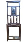 An oak Arts & Crafts style hallstand with pierced detail and rectangular bevelled edge mirror plate,