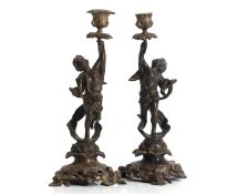 A pair of bronzed metal figural candlesticks, Late 19th to early 20th century