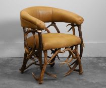 An antler and leather armchair Of recent manufacture