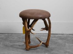 A deer-antler leather stool Of recent manufacture