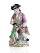 A Continental group as a seated gentleman and his performing dog, late 19th century,