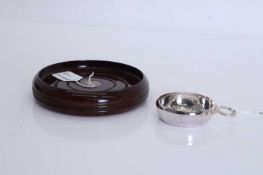 A wooden and silver wine coaster,