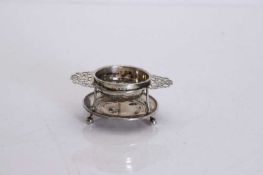 A silver tea strainer and stand,