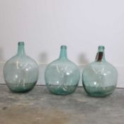 A collection of three pale green demijohns, 20th century, Spanish,