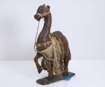 A carved wooden and painted figure of a camel, 20th century,