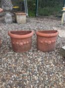 A pair of demi lune terracotta planters,
