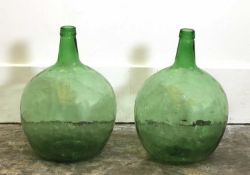 A pair of green Glass Demijohns,
