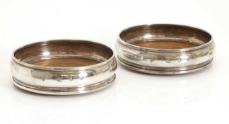 A pair of silver wine coasters,