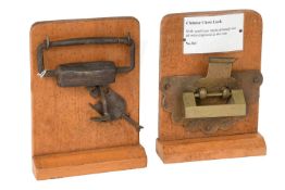 A Chinese Chest Lock, with engraved and foliate decorated backplate, mounted on an oak display stand