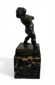 A 19th century patinated bronze Bacchanalian putto on an associated portor marble base