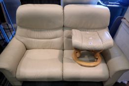 Cream leather two seat couch with matching foot stool, makers name of stressless, W: 174 x D: 72 x