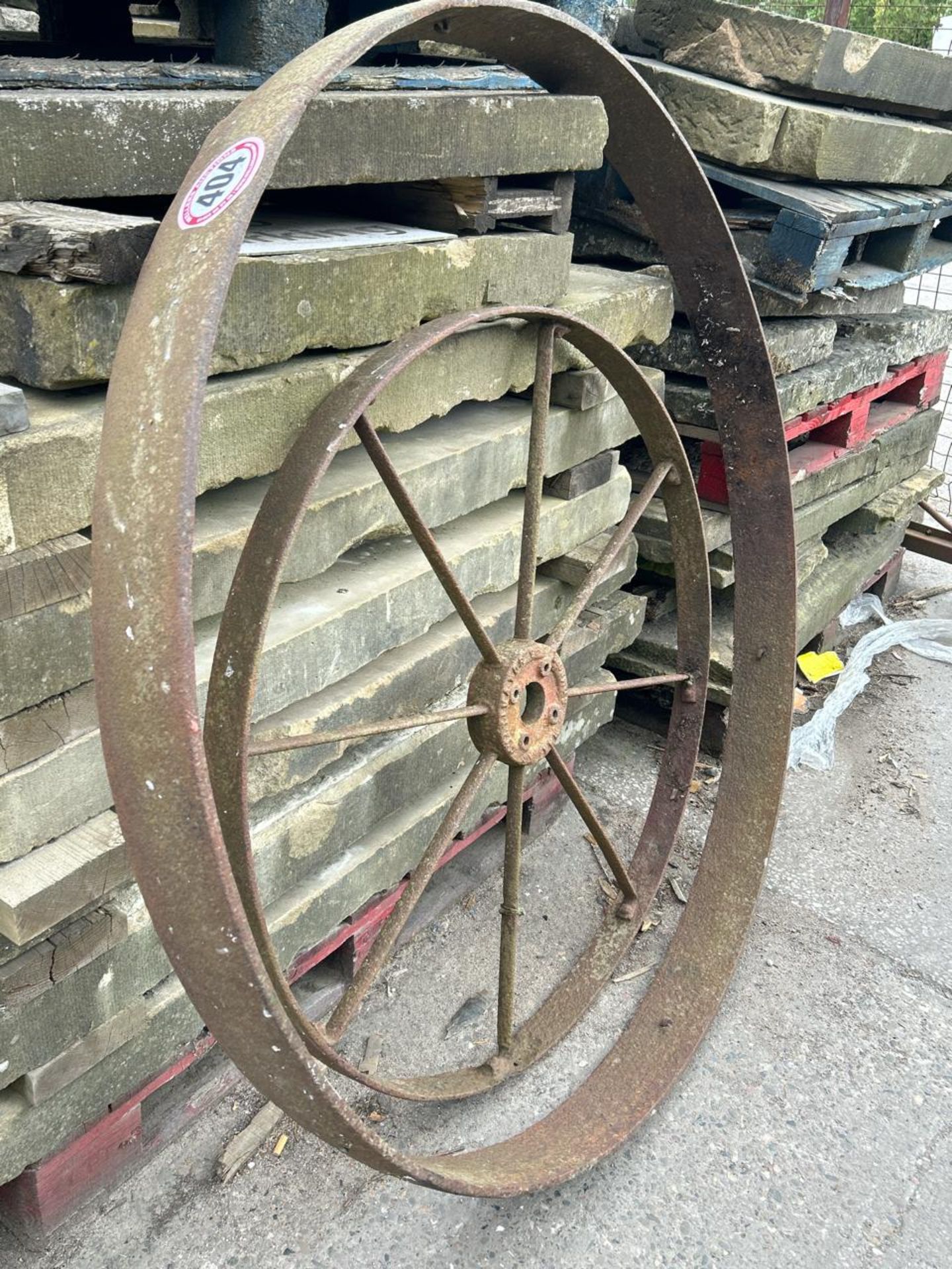 Two cast iron wheels, smaller 108cm diameter, larger 140cm diameter