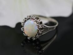Damenring Weißgold 585er Gold mittig ein Opal flankiert mit 12 Diamanten. Der Opal hat