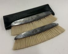 A pair of silver-mounted crumb brushes.