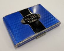 A silver and blue and black enamelled cigarette case.