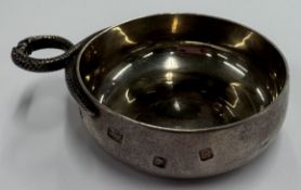 A modernistic silver wine taster.