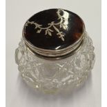 A silver and faux tortoiseshell-lidded glass jar.
