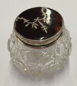 A silver and faux tortoiseshell-lidded glass jar.